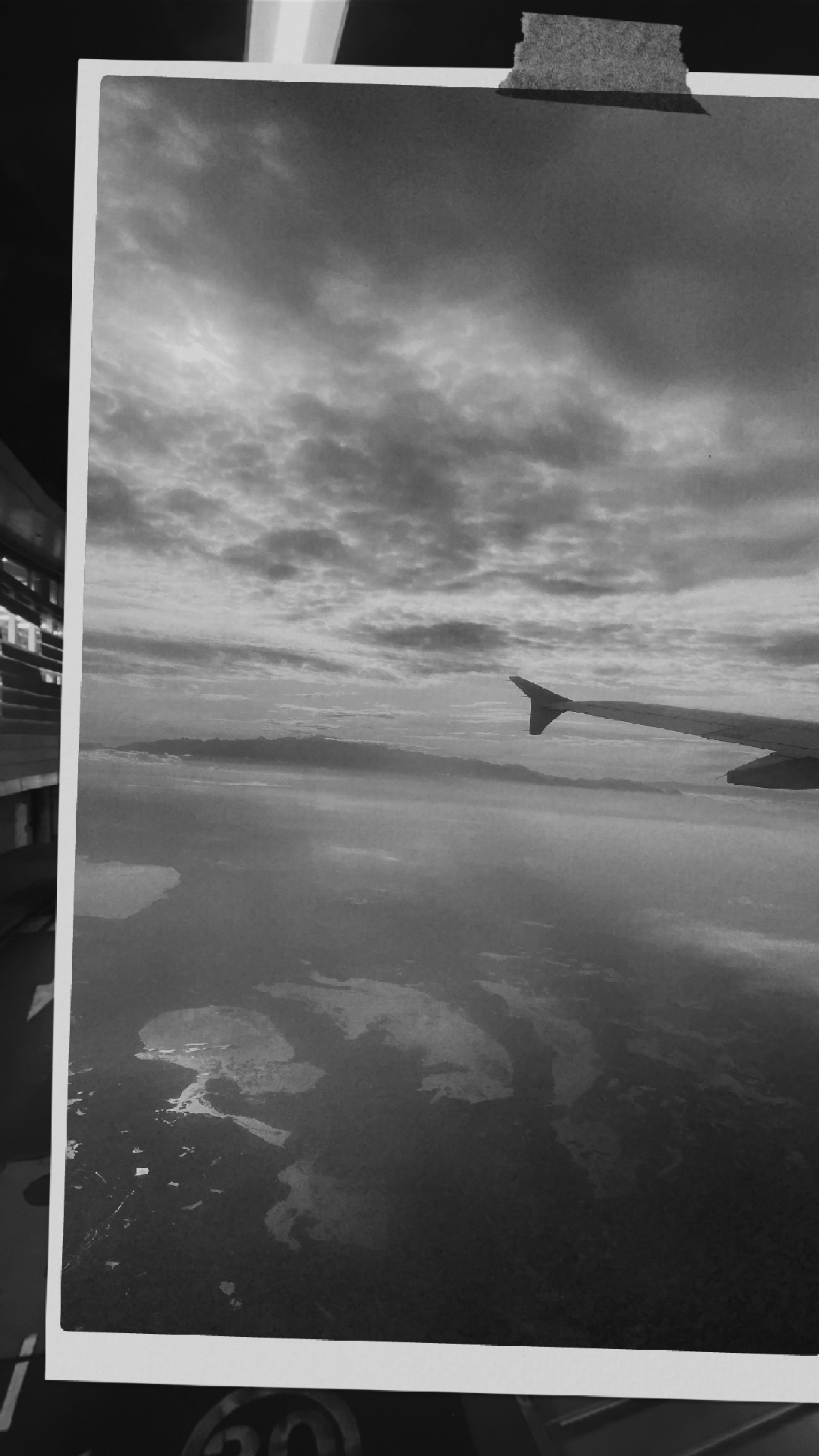 foto del cielo en donde se ven las nubes y la cola de un avion en blanco y negro